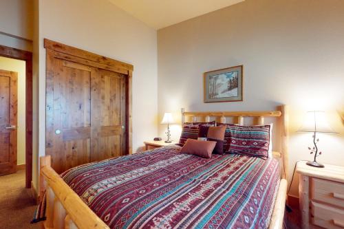 a bedroom with a large bed with a wooden headboard at Copper Valley 114 in Copper Mountain