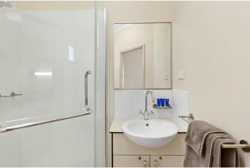 y baño blanco con lavabo y ducha. en Discovery Parks - Roxby Downs, en Roxby Downs