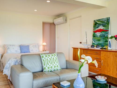 a living room with a couch and a bed at Alexandra Suite Gerroa in Gerroa