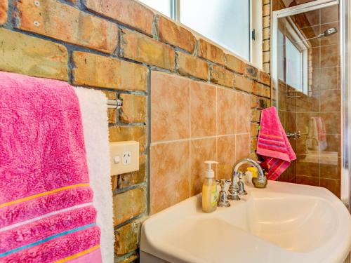 een badkamer met een wastafel en een roze handdoek bij Alexandra Suite Gerroa in Gerroa