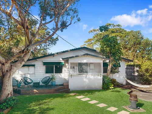 a white house with a tree in the yard at Seaward Werri Beach Gerringong in Gerringong