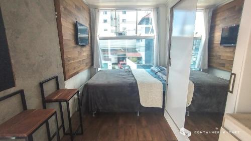 a bedroom with a bed and a large window at Marco Zero Containers 5 in Balneário Camboriú