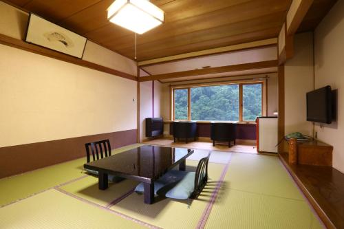 a room with a table and chairs and a window at Fukeikan 風景館 in Takayama
