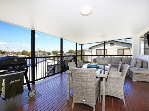 a balcony with a table and chairs and a grill at Shores I Pet Friendly I 1 Min Walk to Beach in Culburra Beach