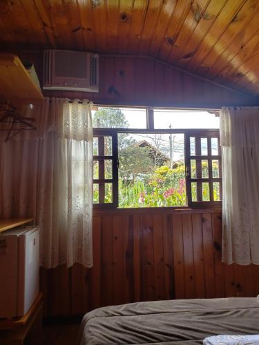 a bedroom with a window with a bed in it at Pousada Bem Te Vi Lumiar in Lumiar