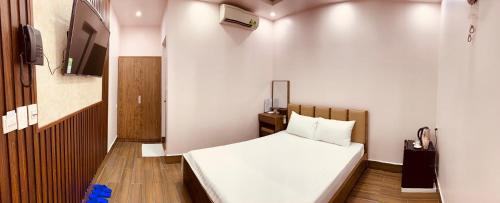 a small room with a bed and a television at MV Hotel in Hai Phong