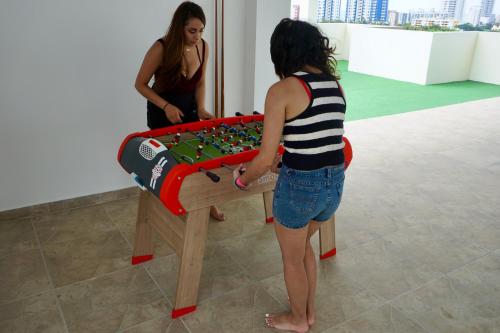 a woman is standing next to a ping pong table at DEPARTAMENTO TOTALMENTE NUEVO, AMOBLADO Y DE LUJO EN TONSUPA in Tonsupa