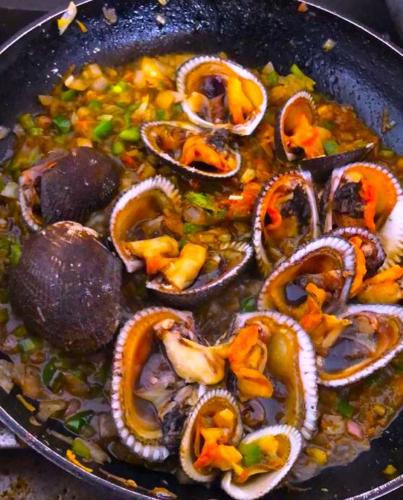 a pan full of food with mushrooms and vegetables at Seaside Garden Ecolodge Mompiche in Mompiche
