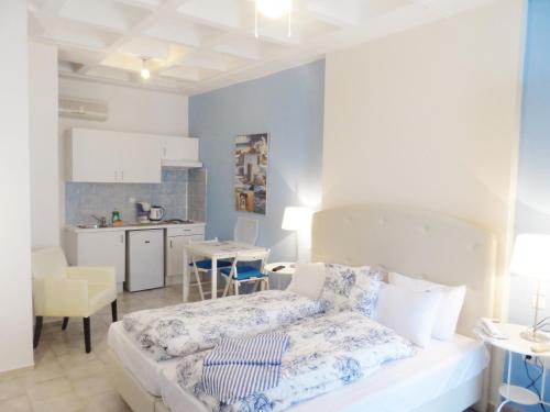 een kleine slaapkamer met een bed en een keuken bij Seafront Studios and Apartments in Chios