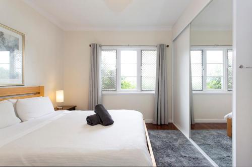 a bedroom with a white bed and two windows at Cosy Cottage -3 Bedrooms Victoria Park in Perth