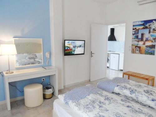 a bedroom with a bed and a table and a desk at Seafront Studios and Apartments in Chios