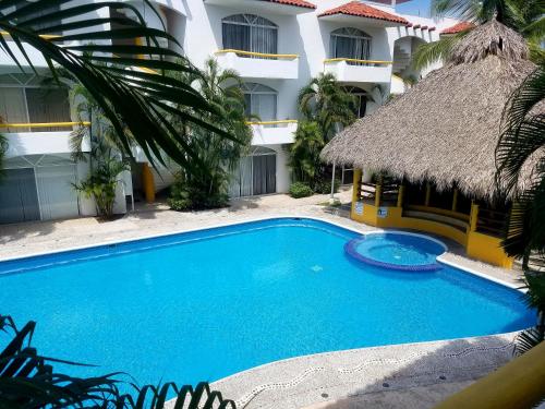 une piscine en face d'un bâtiment dans l'établissement Hacienda Real Suits Ixtapa, à Ixtapa