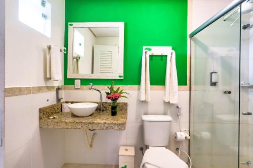 a green bathroom with a toilet and a sink at Pousada Terra Mar Way in Barra Grande