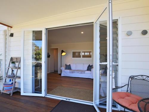 una puerta corredera de cristal que conduce a una sala de estar en Jervis Bay Beach Shack I Pet Friendly, en Vincentia