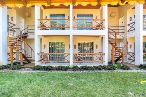 a house with wooden stairs and a grass yard at Pousada Terra Mar Way in Barra Grande