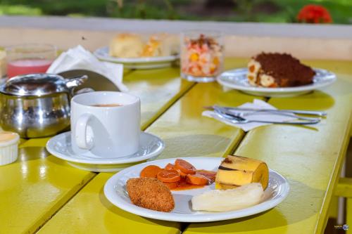 a table with plates of food and a cup of coffee at Pousada Terra Mar Way in Barra Grande