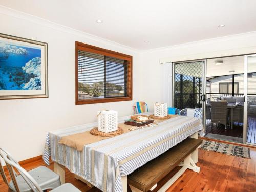 a dining room with a table and chairs at Shores I Pet Friendly I 1 Min Walk to Beach in Culburra Beach