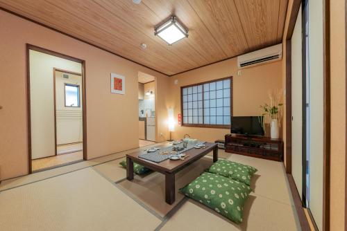 a living room with a table and a television at YADOYA Hakuteian in Tokyo
