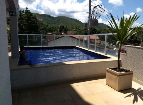 a person sitting on a balcony next to a swimming pool at Serra Madre in Rio Quente