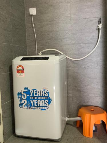 a water heater in a bathroom with an orange stool at HomeSweetHome in Perai