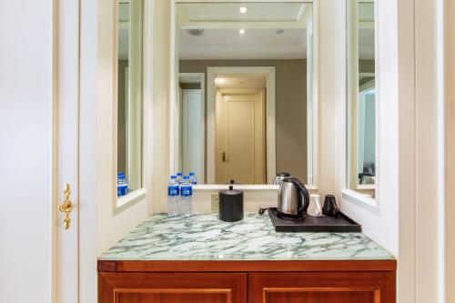 a bathroom counter with a sink and a mirror at Pullman Tangshan in Tangshan