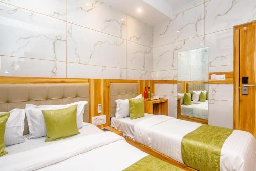 Hotel Al Fatah في مومباي: غرفة نوم بسريرين ومرآة