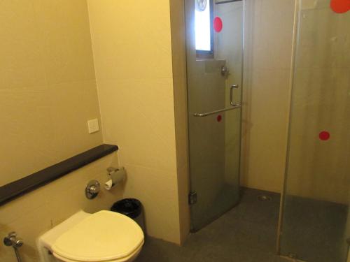 La salle de bains est pourvue d'une douche et de toilettes. dans l'établissement Sandalwood Hotel & Suites, à Panaji