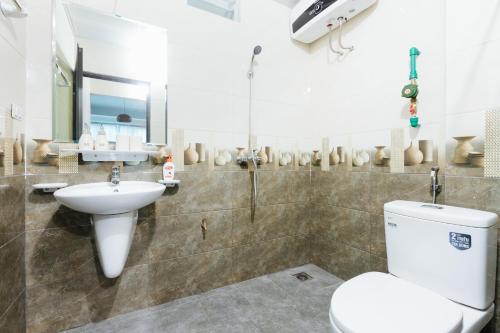 a bathroom with a toilet and a sink at Sunstay Paradise in Hanoi