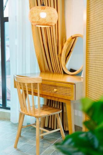a wooden desk with a chair and a mirror at Sunstay Paradise in Hanoi