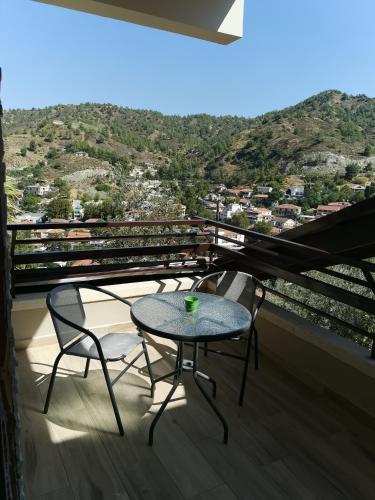 a table and two chairs on a balcony with a view at Kakopetria Heights in Kakopetria