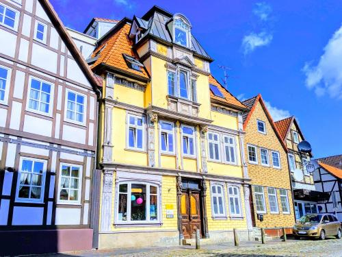 ein gelbes und weißes Gebäude in einer Stadt in der Unterkunft Uhlpartment - im Herzen von Uelzen in Uelzen