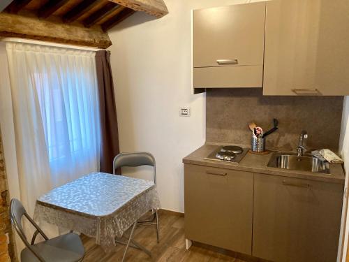a kitchen with a sink and a table with chairs at Barbara's studios in Chioggia