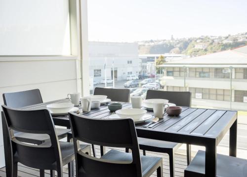a wooden table and chairs in a room with a window at Loft at Shed 5 - Ahuriri Holiday Apartment in Napier