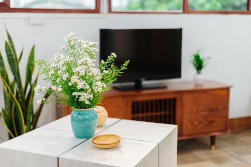 a living room with a vase of flowers on a table at Sunstay Paradise in Hanoi