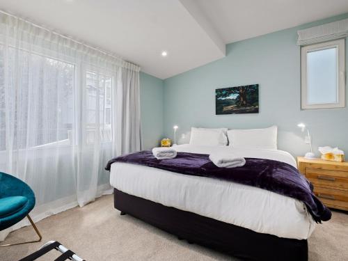 a bedroom with a large bed and a window at Stonehill Villa - 5 Bed in Queenstown