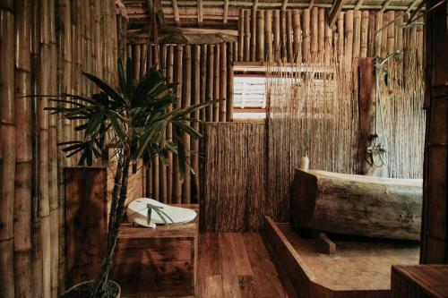 een badkamer met een bad en een potplant bij Treehouse de Valentine in Balamban