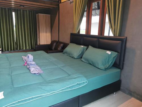 a large bed with a stuffed animal on it at ข้าวทุ่งเบ็ญจาโฮมสเตย์ in Ban Hat Phang