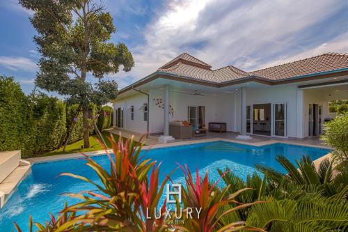 uma villa com uma piscina e uma casa em Modern 3 Bedroom Pool Villa MP67 em Hua Hin