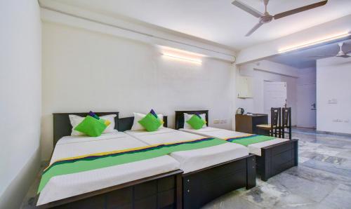 a bedroom with a large bed with green pillows at Treebo Eco Stay Nandanam in Chennai