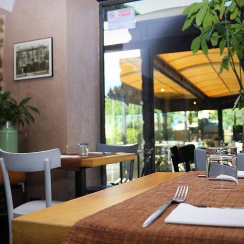 a table and chairs in a restaurant with a table and fork at Al Casaletto Hotel in Settecamini