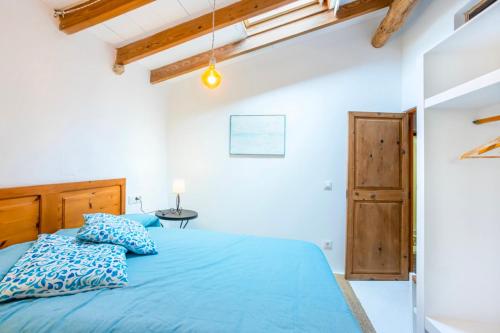 sypialnia z niebieskim łóżkiem z drewnianym zagłówkiem w obiekcie CA NA MIRET w mieście Estellencs
