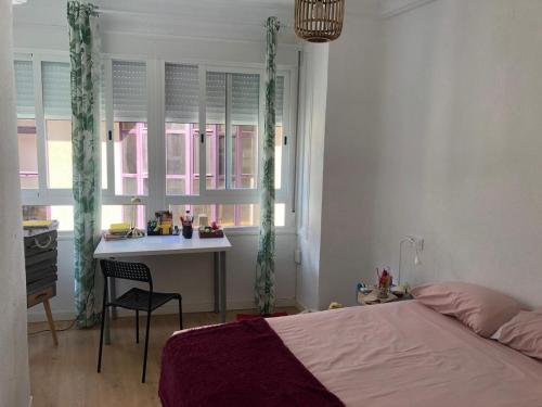 um quarto com uma cama, uma secretária e janelas em Apartamento Sofía em Múrcia