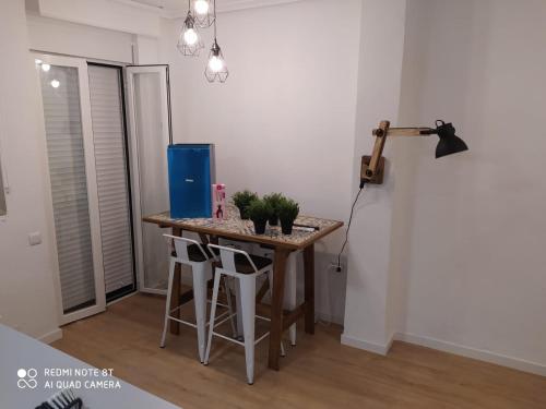 uma pequena cozinha com uma mesa e bancos num quarto em Apartamento Sofía em Múrcia