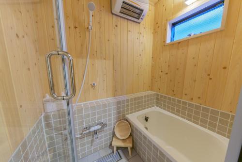 a bathroom with a bath tub and a shower at YADOYA Sennokawa in Tokyo