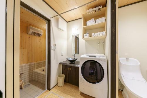 a small bathroom with a washing machine in it at YADOYA Sennokawa in Tokyo