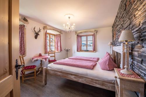 a bedroom with a bed and a stone wall at 5 Sterne Ferienwohnung Sissi in Übersee