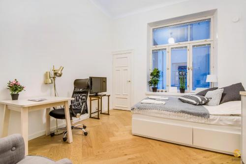 1 dormitorio con cama, escritorio y ventana en Pieni Roobertinkatu Big 13, en Helsinki