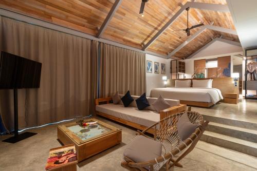 a bedroom with two beds and a couch and a tv at Island Escape Burasari in Phuket Town