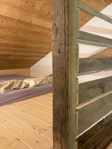 um quarto com uma cama num tecto de madeira em Ferme des Moines em Pontarlier