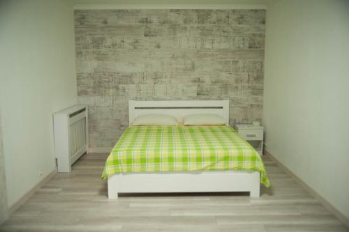 a bedroom with a bed with a green and yellow blanket at Apartment FeLi House in Kyiv